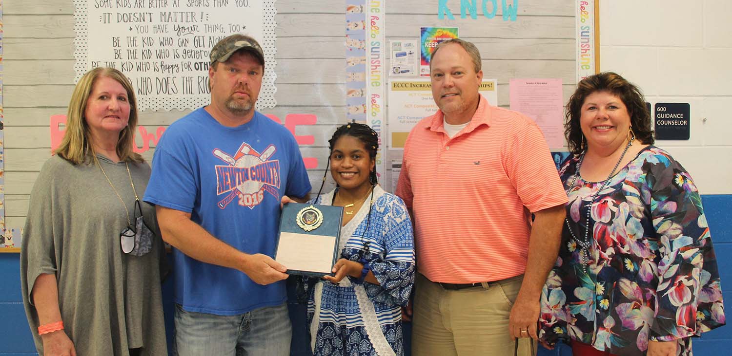 Victoria Ford (center), a graduate of the Newton County High School Class of 2020, was recognized by the School Board of Newton County Schools during the April meeting for her heroic actions involving a bus evacuation on an accident site in December of 2019. The presentation was made by Transportation Director Ray Thomas from left: NC Board President Glenda Barrett, Transportation Director Ray Thomas, Victoria Ford, NC Superintendent J. O. Amis, and NCHS Assistant Principal Dawn Hollingsworth. Submitted photo