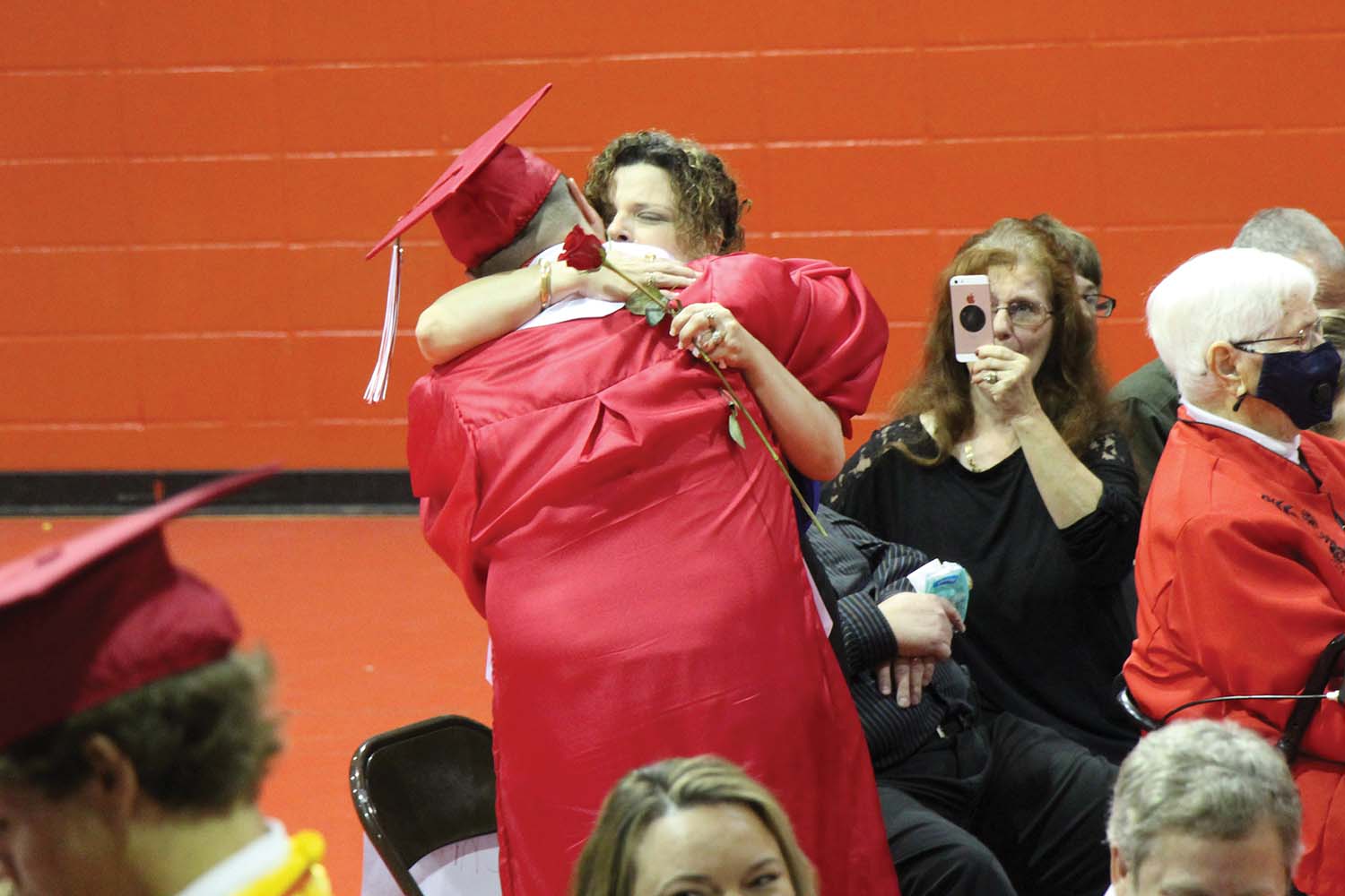 Senior Chris Brooks presents his mom with a rose during graduation