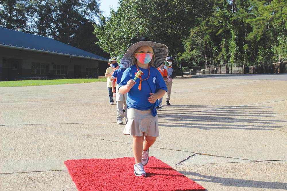 Newton County Elementary School kindergartener Eva Thoms walks the red carpet on Friday as part of her class' Hat Parade. Kindergarten students studied the letter, “H,” this week and sported hats reflecting their interests or personality.