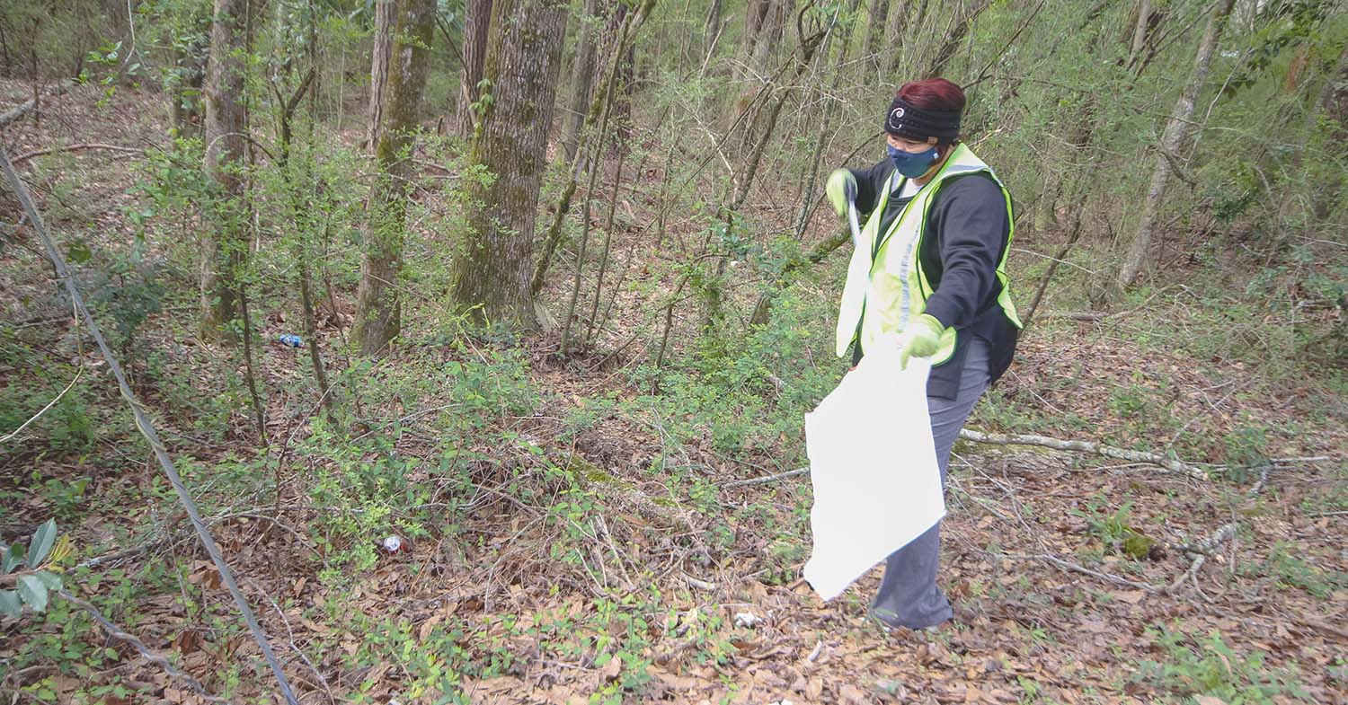 City Clerk Charlene Evans picks up trash along a roadway in Newton on Saturday morning.  Caroline Phillips/The Appeal