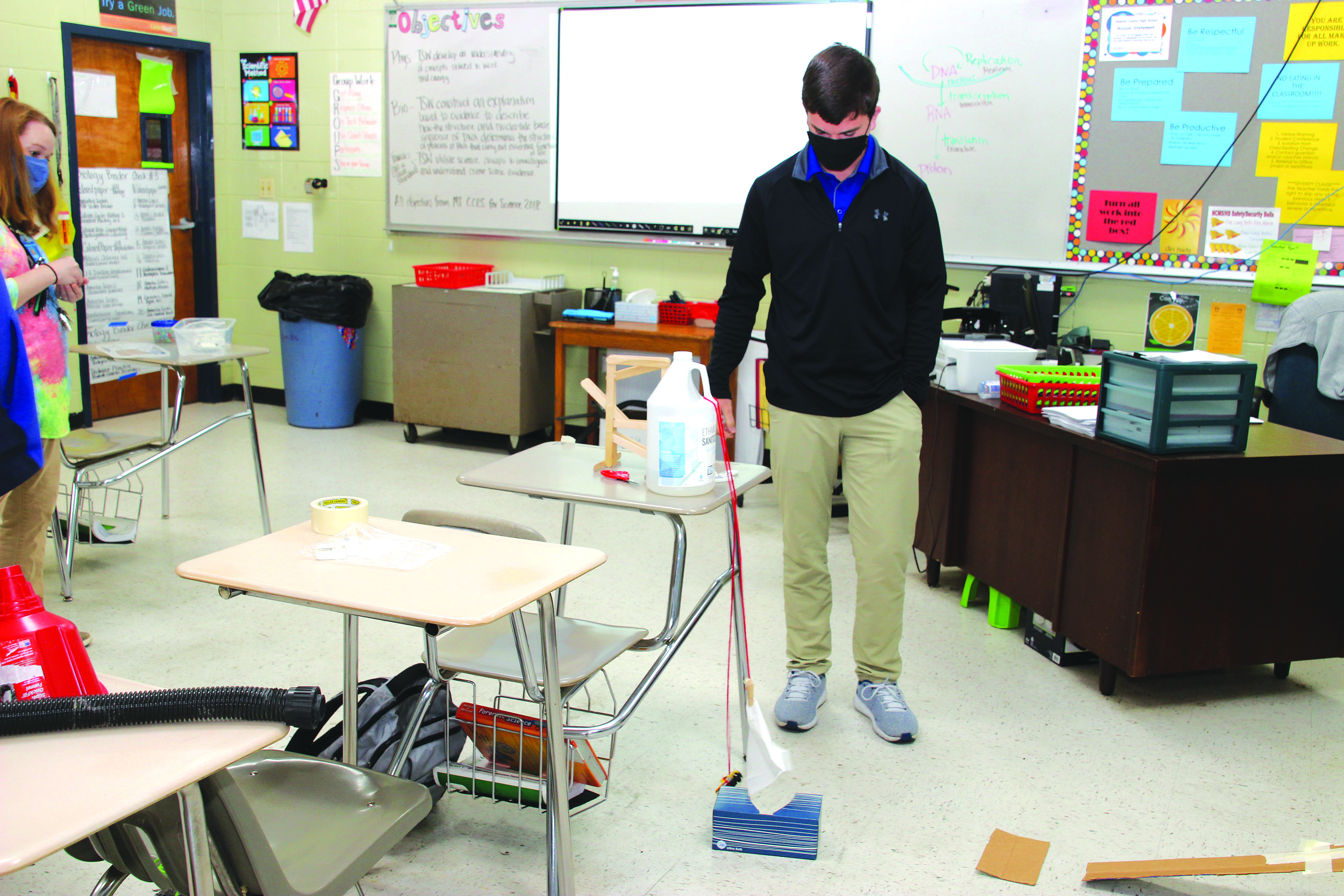 Parker Chaney, a senior at Newton County High School, completes his first test successfully during a trial of his small-scale Rube Goldberg machine as NCHS Physics Teacher Jamie Franklin observes. Submitted photo