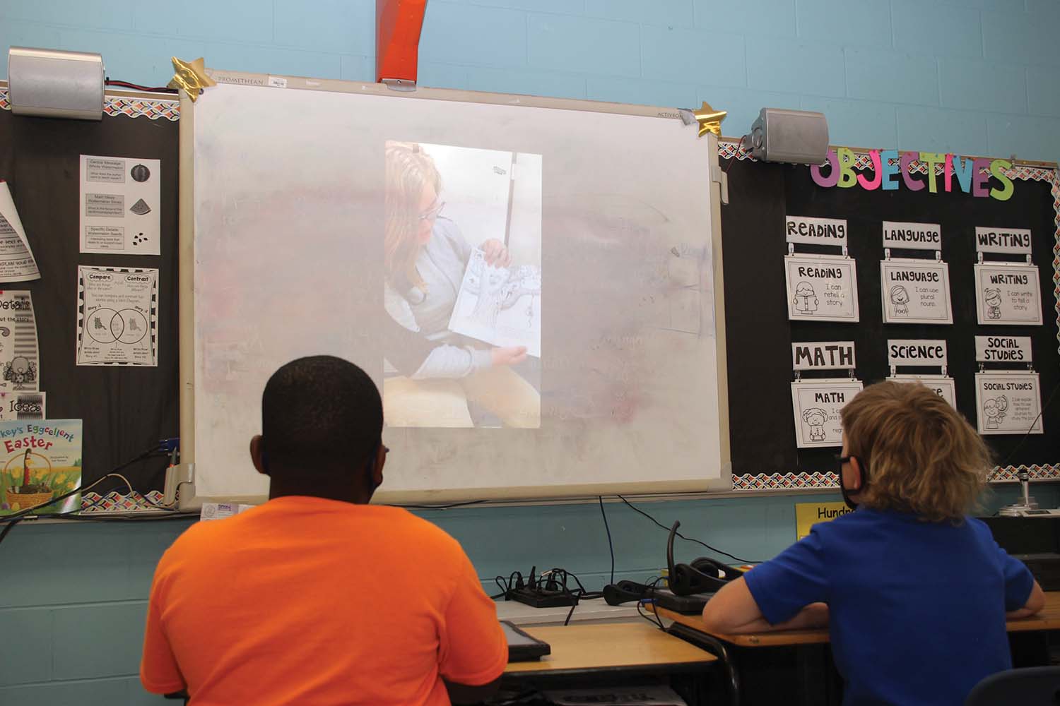 Students in Tiffany Bass’ English classes at Newton County High School volunteered to read in front of a camera in order to continue the tradition of NCHS partnering with students at Newton County Elementary School to help meet the NCES Read Across America campus goal. NCHS ninth grader Kaylean Alonso reads as NCES students Ladarion Cleveland and Mason Dean listen in Jennifer Tune’s second grade classroom. Teachers at NCES are able to match the class reading level with a variety of video selections. Submitted photo