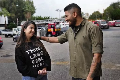 William Noun, right, whose brother Joe was a firefighter and killed during Beirut blast on Aug. 4, 2020, talks to his fiancee Maria Fares, left, whose sister Sahar was also a firefighter and killed in the same blast, at the firefighter headquarters, in Beirut, Lebanon, Wednesday, Dec. 14, 2022. It was a sad moment during which William Noun and Maria Fares met two years ago after their siblings were killed in Beirut's massive port blast. The couple got engaged this month and plan to get married n
