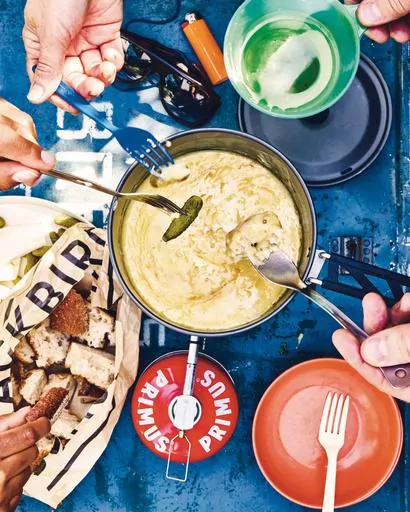 This image released by Clarkson Potter shows a recipe for caramalized shallot-cheese fondue from "Cook It Wild: Sensational Prep-Ahead Meals for Camping, Cabins, and the Great Outdoors" by Chris Nuttall-Smith. (Maya Visnyei /Clarkson Potter via AP)
