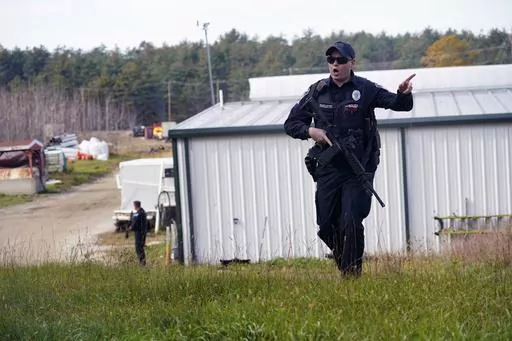 A police officer gives an order to the public during a manhunt for Robert Card at a farm following two mass shootings, Oct. 27, 2023, in Lisbon, Maine. Despite the warning by Card's friend and fellow Army reservist Sean Hodgson, which came alongside a series of other glaring red flags, Army officials discounted the warnings and ultimately did not stop Card from committing Maine's deadliest mass shooting when he killed multiple people in Lewiston. (AP Photo/Robert F. Bukaty, File)