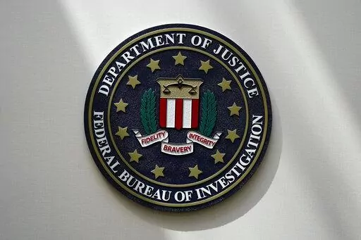 An FBI seal is seen on a wall on Aug. 10, 2022, in Omaha, Neb. The FBI sounded the alarm Monday, Dec. 19, about an explosive increase in teenage boys being targeted online and extorted for money after being tricked into sending sexually explicit pictures. (AP Photo/Charlie Neibergall, File)