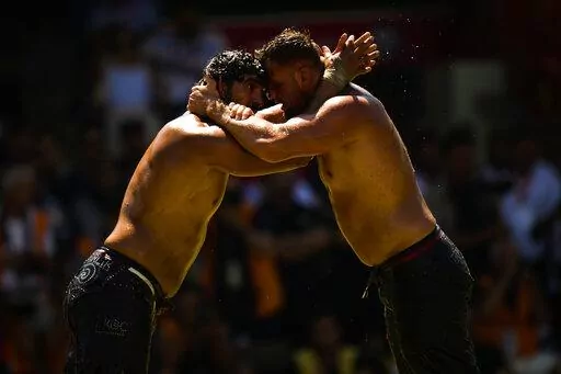 Wrestlers compete during the 661st annual Historic Kirkpinar Oil Wrestling championship, in Edirne, northwestern Turkey, Saturday, July 2, 2022. The festival is part of UNESCO's List of Intangible Cultural Heritages. (AP Photo/Francisco Seco)