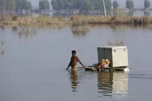 Villagers retrieve belongings, which were they kept on the higher ground, while they wade thorough flooded area, in Qambar Shahdadkot, a flood-hit district of Sindh province, Pakistan, Oct. 25, 2022. At the height of the floods in Sukkur, a city in Sindh that neighbors Baluchistan province, people used boats on the roads. Now, there are few signs the city was ever flooded as hundreds of pumps were brought in. Baluchistan is not so prepared, despite disaster striking it often. Around 75% of Baluc