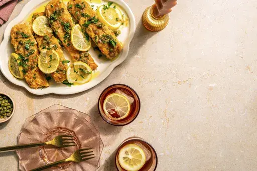 This image released by Chronicle Books shows a recipe for salmon piccata, from the cookbook "A Couple Cooks: 100 Recipes to Cook Together" by Sonja and Alex Overhiser. (Shelly Westerhausen/Chronicle Books via AP)