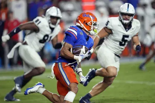 Florida wide receiver Eugene Wilson III, center, runs for an 85-yard touchdown off a pass play past Samford defensive lineman Jamall Thompson (81) and linebacker Noah Martin (5) during the second half of an NCAA college football game, Saturday, Sept. 7, 2024, in Gainesville, Fla. (AP Photo/John Raoux)