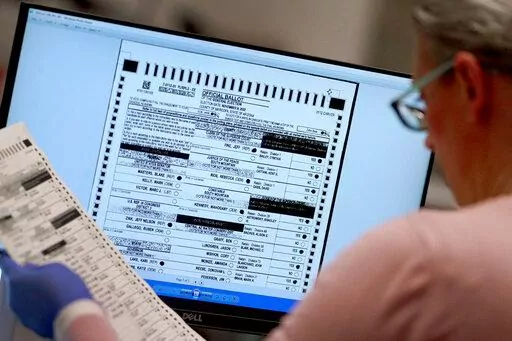 An election worker verifies a ballot on a screen inside the Maricopa County Recorders Office, Thursday, Nov. 10, 2022, in Phoenix. On Friday, Dec. 2, The Associated Press reported on stories circulating online incorrectly claiming Arizona’s Maricopa County announced that more than 540,000 voters visited voting centers on Election Day and that only 248,000 Election Day ballots were counted. Therefore, the county “lost” some 292,000 votes. (AP Photo/Matt York, File)