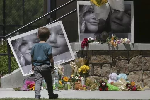 A boy looks at a memorial for Tylee Ryan and Joshua "JJ" Vallow in Rexburg, Idaho, on June 11, 2020. A mother charged with murder in the deaths of her two children is set to stand trial in Idaho. The proceedings against Lori Vallow Daybell beginning Monday, April 3, 2023, could reveal new details in the strange, doomsday-focused case. (John Roark/The Idaho Post-Register via AP, File)