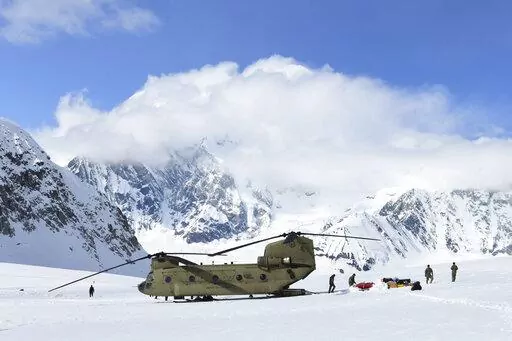 In this photo provided by the U.S. Army, soldiers and National Park Service personnel offload equipment and supplies from a CH-47 Chinook helicopter on Kahiltna Glacier, Alaska, on Wednesday, April 27, 2022. Those wishing to climb North America's tallest peak got a boost this week from the U.S. Army. Aviators from B Company, 1st Battalion, 52nd Aviation Regiment at Fort Wainwright flew two helicopters Wednesday to continue the decades-old tradition of helping set up base camp on Denali, a 20,310