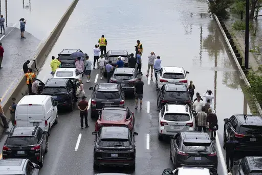 Drivers are stranded due to flood waters blocking the Don Valley Parkway following heavy rain in Toronto, on Tuesday, July 16 2024. (Arlyn McAdorey/The Canadian Press via AP)