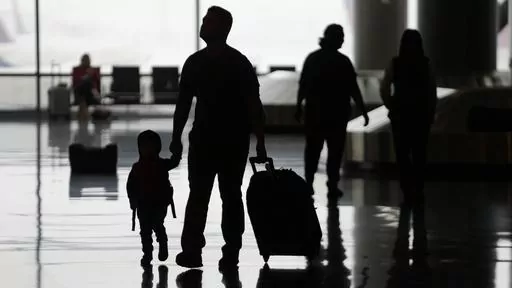 People travel through Salt Lake City International Airport on Wednesday, Feb. 22, 2023, in Salt Lake City. When discussing a multigenerational family trip, have a plan to avoid arguments around topics like when to travel, where you’ll go, what you’ll do there or how you’ll split bills. With groups, it’s often best for each family unit to book their lodging and transportation. (AP Photo/Rick Bowmer, File)