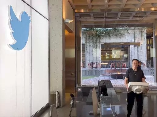 This image from the Twitter page of Elon Musk shows Musk entering Twitter headquarters carrying a sink through the lobby area on Wednesday, Oct. 26, 2022 in San Francisco.  Musk posted a video Wednesday showing him strolling into Twitter headquarters ahead of a Friday deadline to close his $44 billion deal to buy the company.  (Twitter page of Elon Musk via AP)