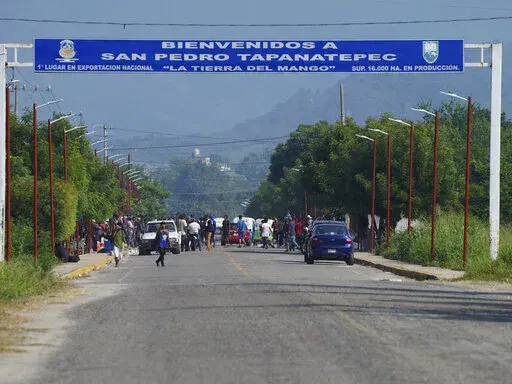 Migrants, mostly from Venezuela, arrive at a camp where Mexican authorities will arrange permits for their continued travel north, in San Pedro Tapanatepec, Oaxaca, Mexico Wednesday, Oct. 5, 2022. As migrants, especially Venezuelans, struggle to come to terms with a new U.S. policy discouraging border crossings, the town of San Pedro Tapanatepec is unexpectedly playing host to over 10,000 migrants camped far from the U.S. border.  (AP Photo/Marco Ugarte)