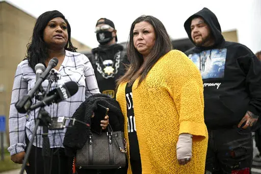 Katie Wright, center, stands beside activist Toshira Garraway and her son, Damik Bryant, during a news conference Thursday, May 5, 2022 outside the Brooklyn Center Police Station in Brooklyn Center, Minn. Katie Wright, the mother of Daunte Wright, said she was injured while she was briefly detained by one of the same department’s officers after she stopped to record an arrest of a person during a traffic stop.  (Aaron Lavinsky /Star Tribune via AP)