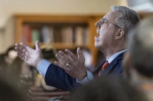Pastor George Grant leads a prayer during a Palm Sunday service at Parish Presbyterian Church Sunday, April 2, 2023, in Franklin, Tenn. (AP Photo/Wade Payne)
