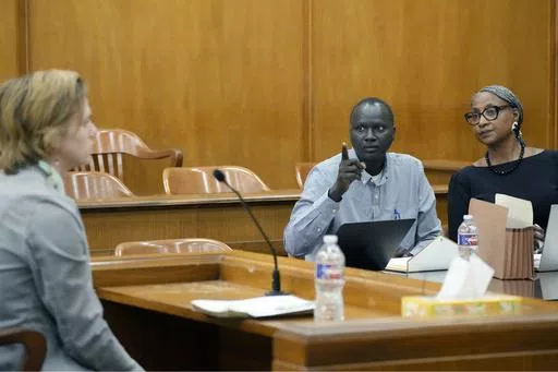 Lisa Ross, right, attorney for Bul Mabil, seated center, brother of Dau Mabil, a 33-year-old Jackson, Miss., resident who went missing on March 25 and whose body was found in April floating in the Pearl River in Lawrence County, listens to his question, while Karissa Bowley, wife of the deceased, awaits a renewed spate of questions during a hearing, on whether a judge should dissolve or modify his injunction preventing the release of Mabil's remains until an independent autopsy could be conducte