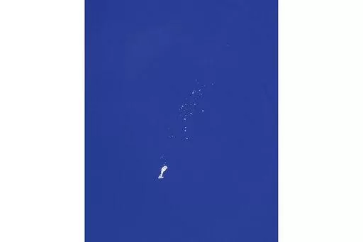 The remnants of a large balloon descend after it was struck by a missile from an F-22 fighter jet over the Atlantic Ocean, just off the coast of South Carolina near Myrtle Beach, Feb. 4, 2023. China's ceremonial parliament has accused American lawmakers of trampling on the sovereignty of other nations after the U.S. passed a measure condemning a suspected Chinese spy balloon's intrusion into U.S. airspace. (Chad Fish via AP, File)