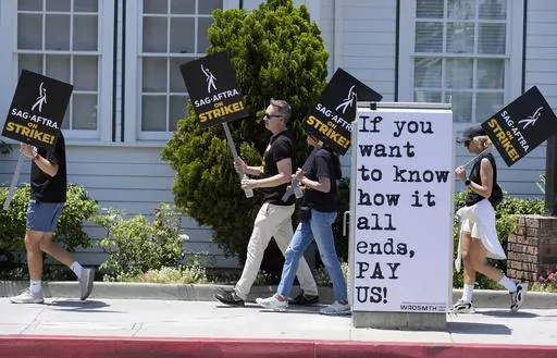 Picketers carry signs outside Amazon Studios in Culver City, Calif. on Monday, July 17, 2023. A tentative agreement between striking screenwriters and Hollywood studios offers some hope that the industry’s dual strikes may be over soon. (AP Photo/Chris Pizzello, File)
