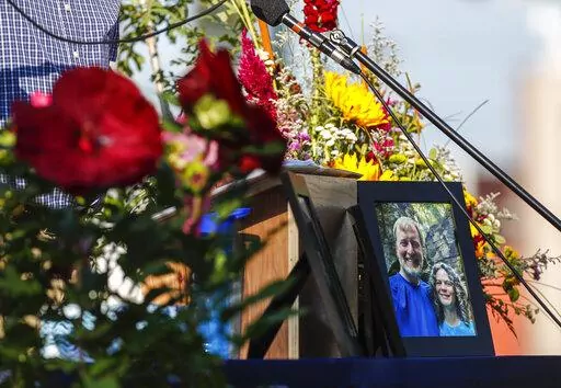 A photo of Tyler and Sarah Schmidt sits on the podium during the Celebration of Life event for Tyler, Sarah, and Lula Schmidt held at Overman Park on Tuesday, Aug. 2 2022 in Cedar Falls, Iowa. The Schmidt's were shot and killed at Maquoketa Caves State Park on July 22. (Chris Zoeller/The Courier via AP)
