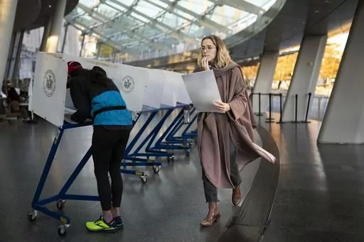 FILE — A voter moves to cast her ballot at an electronic counting machine at a polling site at the Brooklyn Museum, Nov. 8, 2022, in the Brooklyn borough of New York. New York’s highest court just gave Democrats a chance to redraw the state’s congressional districts, a major victory as the party tries to flip seats in the state to win control of the U.S. House next year. ( AP Photo/John Minchillo, File)
