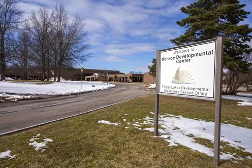 A sign for the Monroe Developmental Center at the Finger Lakes Developmental Disabilities Service Office on Wednesday, March 8, 2023, in Rochester, N.Y. A woman born to a severely disabled resident of the facility in 1986 has filed a lawsuit saying her mother was raped by an employee whose abuse was covered up by those in charge. (AP Photo/Lauren Petracca)