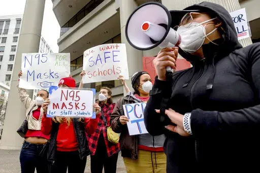 Teachers protest for stronger COVID-19 safety protocols outside Oakland Unified School District headquarters on Jan. 7, 2022, in Oakland, Calif. Officials across the U.S. are again weighing how and whether to impose mask mandates as COVID-19 infections soar and the American public grows weary of pandemic-related restrictions. Much of the debate centers around the nation’s schools, some of which closed due to infection-related staffing issues. (AP Photo/Noah Berger, File)