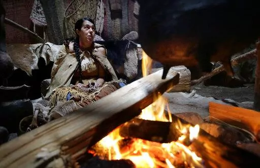 Mashpee Wampanoag Kerri Helme, of Fairhaven, Mass., uses plant fiber to weave a basket while sitting next to a fire on November 15, 2018, at the Wampanoag Homesite at the Plimoth Patuxet Museums, in Plymouth, Mass. Native Americans in Massachusetts are calling for a boycott of a popular living history museum featuring colonial reenactors portraying life in Plymouth, the famous English settlement founded by Pilgrims arriving on the Mayflower. They say the Plimoth Patuxet museum hasn't lived up to