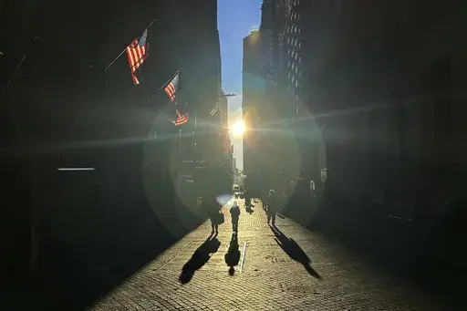 The morning sun shines on Wall Street in New York's Financial District on Tuesday, Nov. 19, 2024. (AP Photo/Peter Morgan)