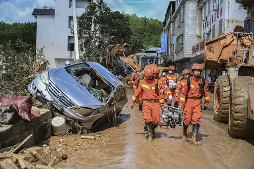 In this photo released by Xinhua News Agency, rescuers carrying rescue equipment enter a flood-affected area in Wuping County of Longyan City, southeast China's Fujian Province, Thursday, June 20, 2024. A family of six was found dead by rescuers in Fujian province, state media reported Saturday, adding to the extreme weather deaths after downpours caused landslides in the area, even as authorities extended a warning of more severe weather ahead. (Zhou Yi/Xinhua via AP)
