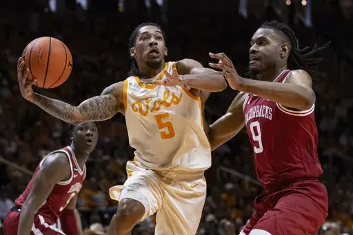 Tennessee guard Zakai Zeigler (5) drives for a shot past Arkansas forward Jonas Aidoo (9) during the first half of an NCAA college basketball game Saturday, Jan. 4, 2025, in Knoxville, Tenn. (AP Photo/Wade Payne)