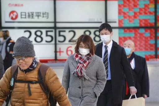 People walk by an electronic stock board of a securities firm in Tokyo, Friday, Jan. 7, 2022. Asian markets are mostly higher after more declines in big technology stocks pulled major indexes lower on Wall Street. Tokyo and Taiwan declined but other regional markets advanced. U.S. futures also were higher.(AP Photo/Koji Sasahara)