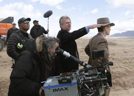 This image released by Universal Pictures shows director Christopher Nolan, center, and Cillian Murphy, right, on the set of "Oppenheimer." (Melinda Sue Gordon/Universal Pictures via AP)