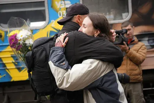 People hug upon the arrival of the first train from the capital Kyiv, after the Russian troops withdrew from the city of Kherson, Ukraine, Saturday, Nov. 19, 2022. (AP Photo/Sam Mednick)