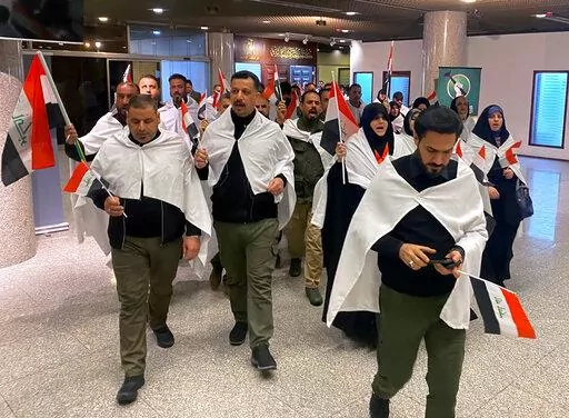 Newly elected lawmakers from the Sadr political bloc ​prepare to attend the first parliament session, in Baghdad, Iraq, Sunday, Jan. 9, 2022. Iraq's newly-elected parliament is expected to hold its first session on Sunday, nearly three months after Iraqis went to the polls in a national vote whose results have been contested by powerful Iran-backed factions. (AP Photo/Ali Abdul Hassan)