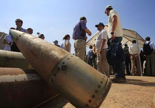 Activists and international delegations stand next to cluster bomb units, during a visit to a Lebanese military base at the opening of the Second Meeting of States Parties to the Convention on Cluster Munitions, in the southern town of Nabatiyeh, Lebanon, Monday Sept. 12, 2011.  Rights groups and observers say Russia is using cluster bombs in its invasion of Ukraine, a charge Moscow denies. If confirmed, deployment of the weapon, especially in crowded civilian areas, would usher in new humanitar