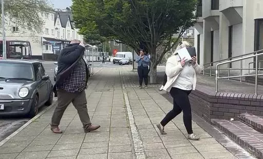 In this still image taken from video, Ann and Bernard McDonagh arrive at Swansea Crown Court in Wales, Wednesday, May 29, 2024. The couple were sentenced to prison for fraud for routinely ordering pricey meals at restaurants and then bolting when it came time to pay. (Claire Hayhurst/PA via AP)