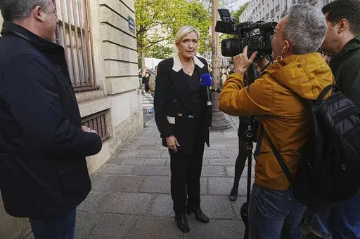 French far-right leader Marine Le Pen answers to the media during a gathering in support of detained Franco-Algerian writer Boualem Sansal, in Paris, Tuesday, March 25, 2025. (AP Photo/Thibault Camus, File)
