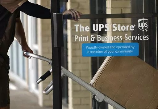 A UPS driver enters a United Parcel Service store with packages in Jackson, Miss., Monday, July 26, 2021.  With enough time and the right tools, online clothing resale can become a profitable side gig or even a full-time job. But before you start selling online, factor in recurring costs such as shipping labels, storage and fees from the resale app and payment processor you use. Other factors like communicating with buyers, taking high-quality photos and promoting your items on social media can 