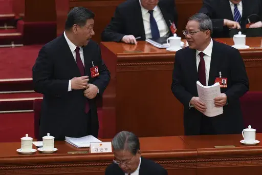 Chinese Premier Li Qiang, right, chats with Chinese President Xi Jinping after the opening session of the National People's Congress (NPC) at the Great Hall of the People in Beijing, China, Wednesday, March 5, 2025. (AP Photo/Ng Han Guan)