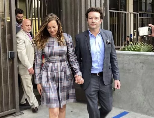 Actor Danny Masterson leaves Los Angeles superior Court with his wife Bijou Phillips after a judge declared a mistrial in his rape case in Los Angeles on Nov. 30, 2022. Masterson is going back on trial on three charges of rape. A deadlocked jury led to a mistrial for Masterson in November. Opening statements in his retrial will begin on Monday. (AP Photo/Brian Melley, File)