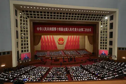 Chinese Premier Li Qiang is seen on screens as he speaks during the opening session of the National People's Congress (NPC) at the Great Hall of the People in Beijing, on March 5, 2024. (AP Photo/Ng Han Guan, File)