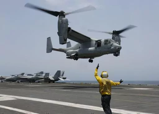 FILE -In this image provided by the U.S. Navy, Aviation Boatswain's Mate 2nd Class Nicholas Hawkins, signals an MV-22 Osprey to land on the flight deck of the USS Abraham Lincoln in the Arabian Sea on May 17, 2019. When the U.S. military took the extraordinary step of grounding its fleet of V-22 Ospreys this week, it wasn't reacting just to the recent deadly crash of the aircraft off the coast of Japan. The aircraft has had a long list of problems in its short history. (Mass Communication Specia
