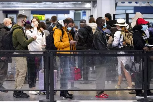Travelers line up for flights at O'Hare International Airport in Chicago, Thursday, Dec. 30, 2021. (AP Photo/Nam Y. Huh)