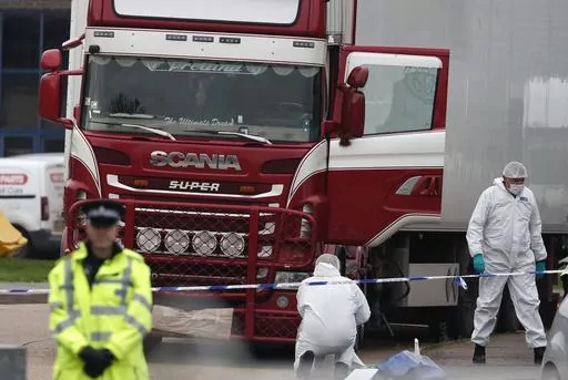 Forensic police officers attend the scene after a truck was found to contain a large number of dead bodies, in Grays, England, Oct. 23, 2019. A Romanian man who was part of an international human smuggling ring was sentenced Tuesday July 11, 2023, to more than 12 years in prison for the deaths of 39 migrants from Vietnam who suffocated were found lifeless in a truck trailer in England in 2019. Marius Mihai Draghici, 50, pleaded guilty last month to 39 counts of manslaughter and conspiracy to ass