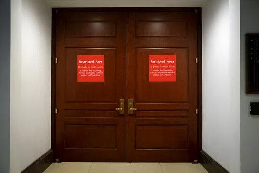 Bright red signs alert non-authorized personnel at the entrance to the House SCIF, the Sensitive Compartmented Information Facility, located three levels beneath the Capitol where witnesses and lawmakers hold closed interviews in the impeachment inquiry on President Donald Trump's efforts to press Ukraine to investigate his political rivals, in Washington, Nov. 6, 2019. When members of Congress want to peruse classified materials, they descend deep into the basement of the Capitol to a sensitive