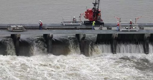 Workers open bays of the Bonnet Carre Spillway to divert rising water from the Mississippi River to Lake Pontchartrain, upriver from New Orleans, in Norco, La., May 10, 2019. Several local governments and business groups on the Mississippi Gulf Coast filed a lawsuit Monday, Jan. 22, 2024, saying that the U.S. Army Corps of Engineers' opening of the spillway in 2019 sent polluted fresh water from the Mississippi River into the Gulf of Mexico and killed bottlenose dolphins that live in saltwater. 